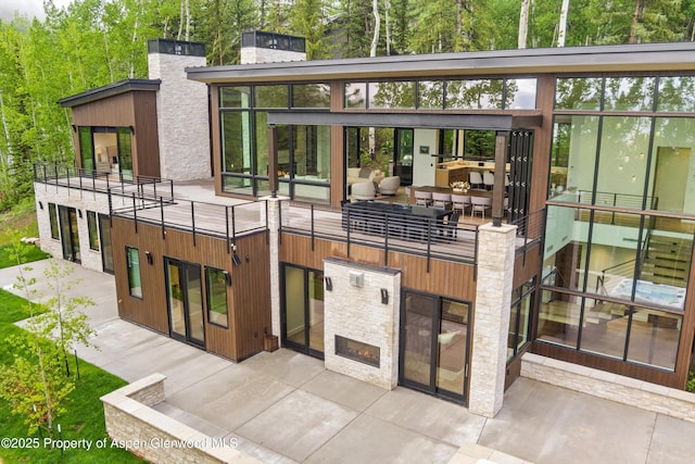 1234 Wood Rd, Snowmass Village, CO 81615 - back of house with a warm lit fireplace, a chimney, a patio, and a balcony