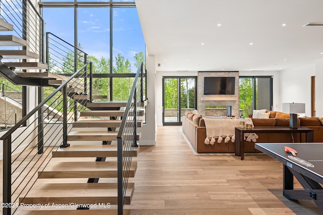 1234 Wood Rd, Snowmass Village, CO 81615 - living room featuring stairs, light wood-style flooring, a fireplace, and recessed lighting