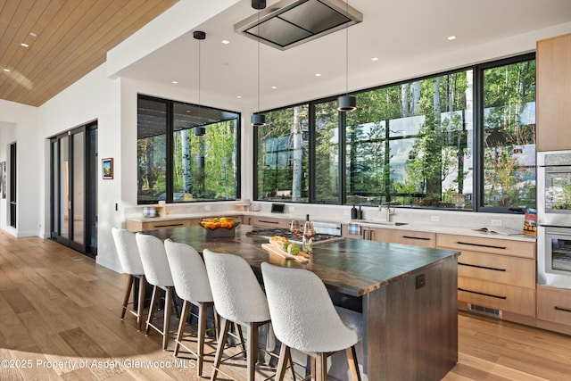 1234 Wood Rd, Snowmass Village, CO 81615 - kitchen featuring modern cabinets, light brown cabinetry, a sink, a kitchen bar, and light wood finished floors