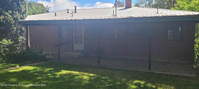 888 Pershing St, Craig, CO 81625 - rear view of house featuring a yard, entry steps, a chimney, and a metal roof
