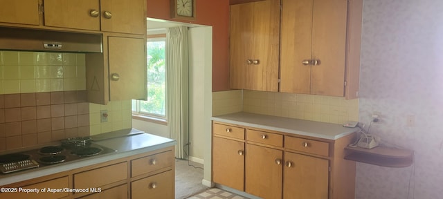 888 Pershing St, Craig, CO 81625 - kitchen with electric stovetop, backsplash, light countertops, and under cabinet range hood