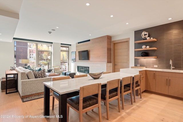 interior space with a fireplace, sink, and light hardwood / wood-style flooring