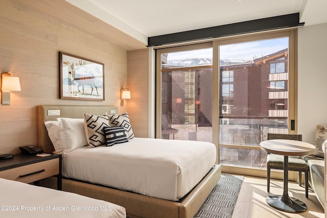 bedroom with multiple windows and wood walls