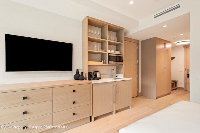 bedroom featuring light wood-type flooring and sink