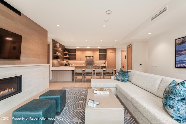 living room with wooden walls and a tile fireplace