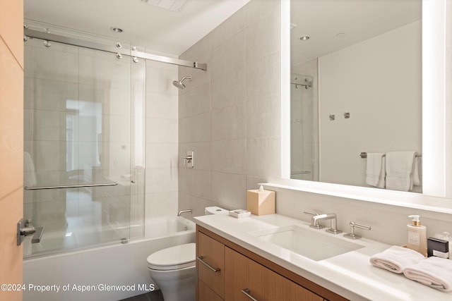 full bathroom with vanity, toilet, and enclosed tub / shower combo