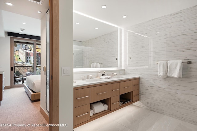 bathroom featuring vanity, tile walls, and walk in shower