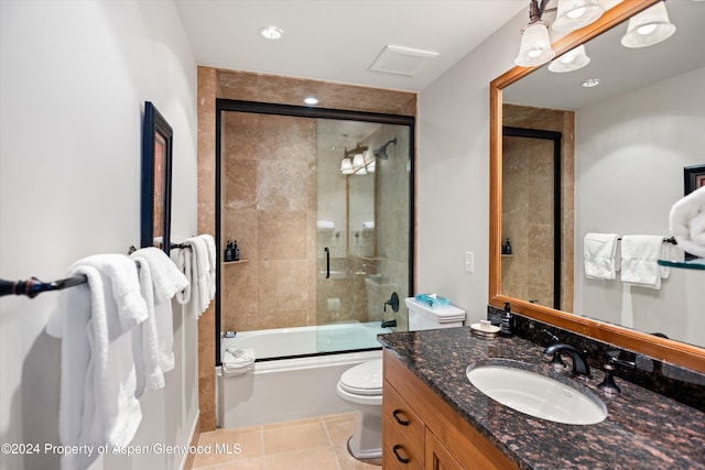 full bathroom with toilet, vanity, tile patterned floors, and enclosed tub / shower combo