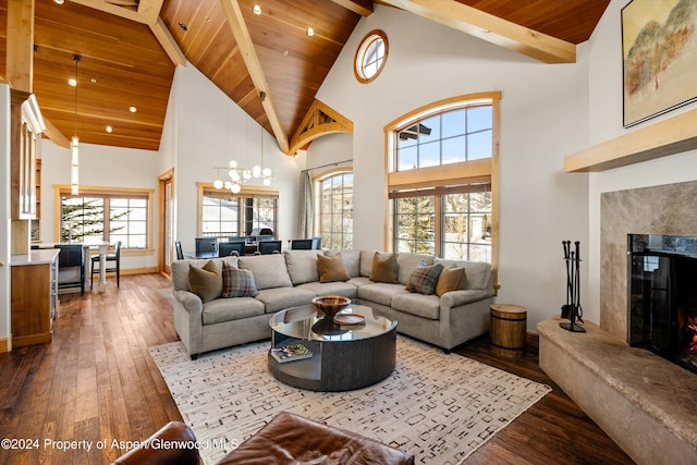 living room featuring a tiled fireplace, high vaulted ceiling, wood ceiling, and wood-type flooring