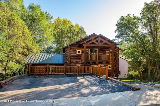 log-style house featuring a wooden deck