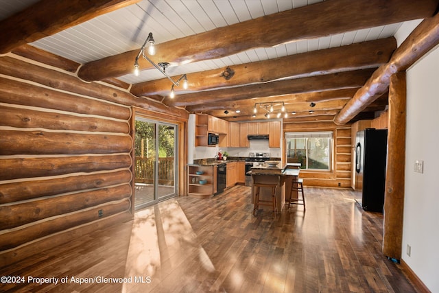 kitchen featuring beam ceiling, a center island, log walls, and black appliances