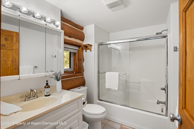 full bathroom featuring shower / bath combination with glass door, tile patterned flooring, vanity, and toilet