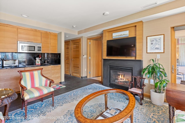 130 Wood Rd Unit 625, Snowmass Village, CO 81615 - living area with a glass covered fireplace, dark tile patterned flooring, and recessed lighting