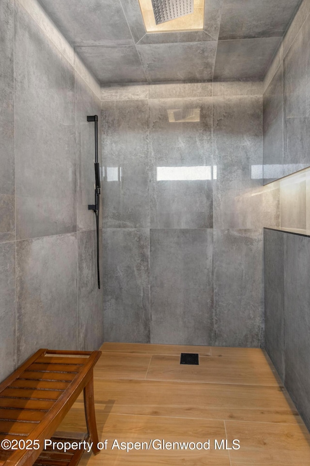 full bathroom with tiled shower and visible vents