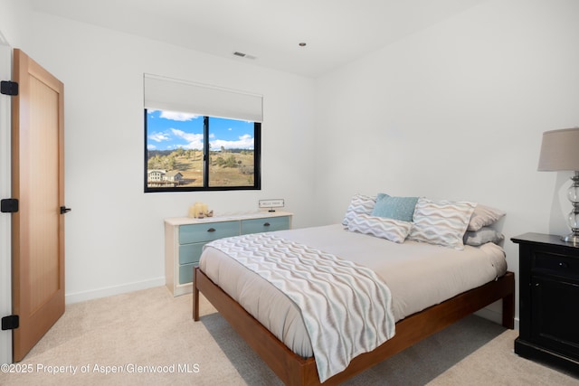 bedroom featuring baseboards, visible vents, and light colored carpet