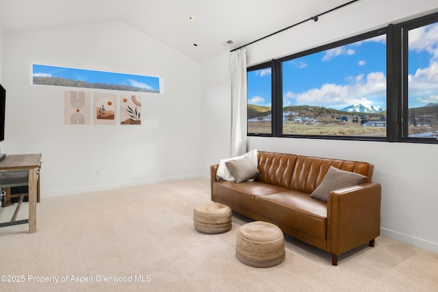 carpeted living room with baseboards and vaulted ceiling