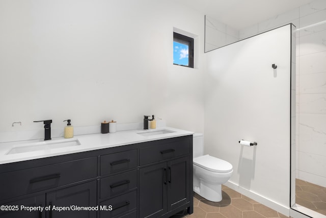 bathroom featuring double vanity, toilet, a sink, tile patterned flooring, and tiled shower