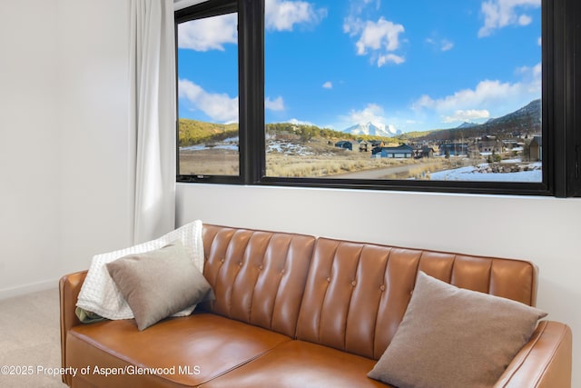 living area with carpet flooring, a mountain view, and baseboards