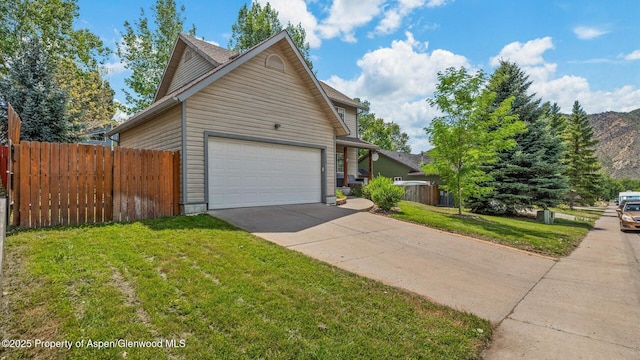 view of front of home featuring a mountain view, a garage, fence, concrete driveway, and a front yard