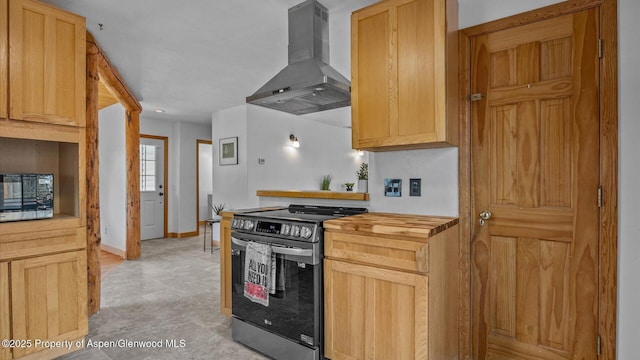 kitchen featuring stainless steel appliances, light brown cabinetry, wood counters, baseboards, and extractor fan