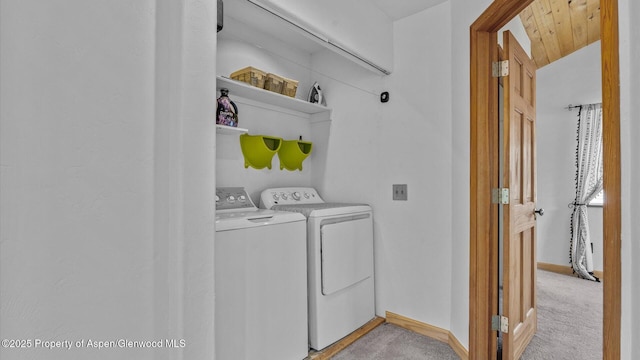 washroom featuring washer and dryer, laundry area, light carpet, and baseboards