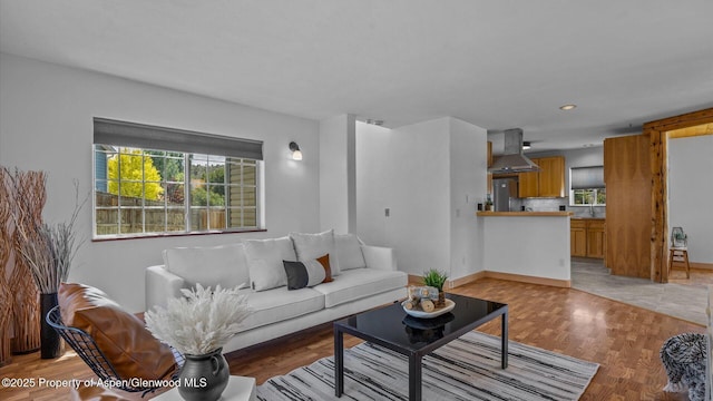 living area featuring light wood-style floors, baseboards, and recessed lighting