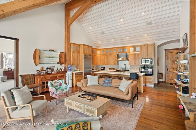 living area with beamed ceiling, dark wood-style floors, and high vaulted ceiling