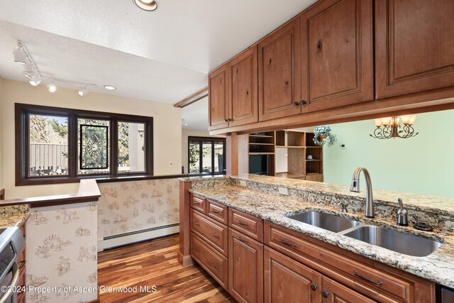 211 Meadow Ranch Dr Unit D5A, Snowmass Village, CO 81615 - kitchen featuring baseboard heating, a sink, light wood-style floors, and brown cabinetry