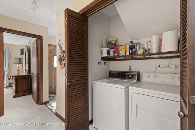 211 Meadow Ranch Dr Unit D5A, Snowmass Village, CO 81615 - laundry room featuring washing machine and clothes dryer, light colored carpet, and a textured ceiling