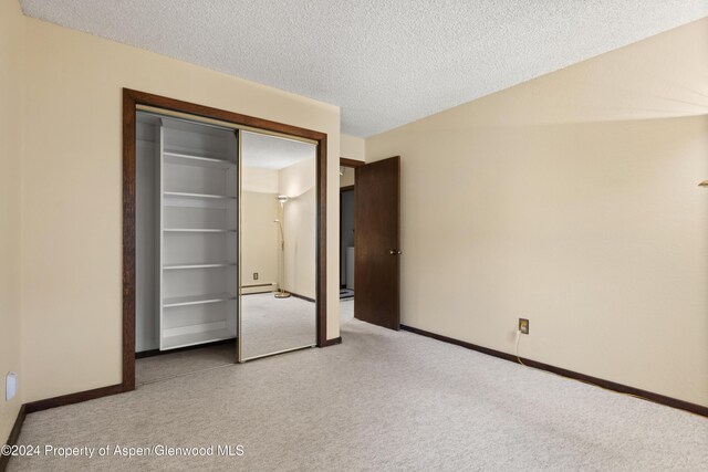 211 Meadow Ranch Dr Unit D5A, Snowmass Village, CO 81615 - unfurnished bedroom with carpet floors, baseboards, a textured ceiling, a closet, and a baseboard heating unit