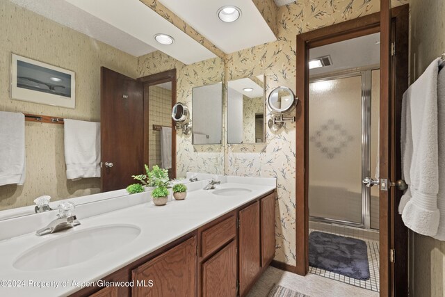 211 Meadow Ranch Dr Unit D5A, Snowmass Village, CO 81615 - bathroom with wallpapered walls, a stall shower, double vanity, and tile patterned floors