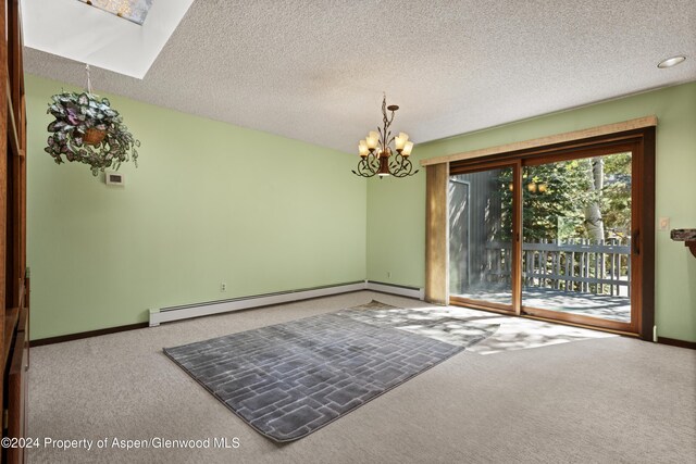 211 Meadow Ranch Dr Unit D5A, Snowmass Village, CO 81615 - carpeted spare room featuring a baseboard heating unit, a chandelier, baseboards, a textured ceiling, and a skylight
