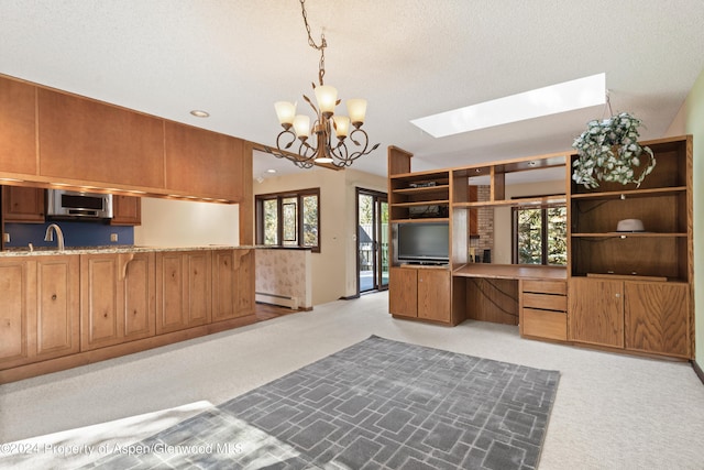 211 Meadow Ranch Dr Unit D5A, Snowmass Village, CO 81615 - kitchen with stainless steel microwave, light carpet, a skylight, brown cabinets, and recessed lighting