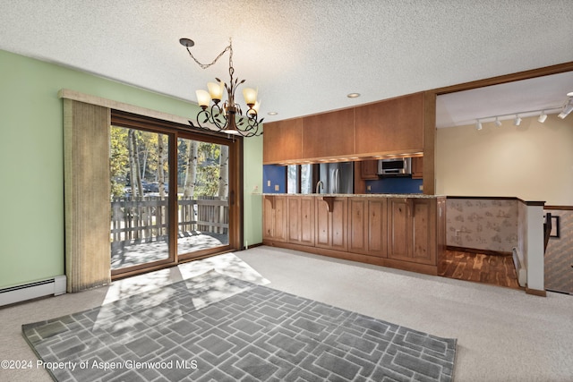 211 Meadow Ranch Dr Unit D5A, Snowmass Village, CO 81615 - kitchen with carpet flooring, appliances with stainless steel finishes, a chandelier, baseboard heating, and rail lighting