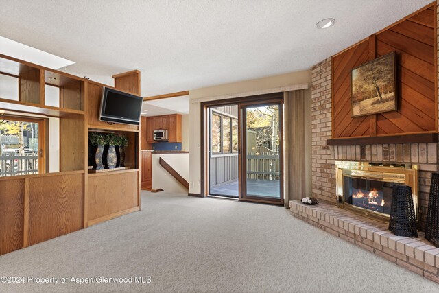 211 Meadow Ranch Dr Unit D5A, Snowmass Village, CO 81615 - unfurnished living room with a fireplace, carpet, a textured ceiling, recessed lighting, and wood walls