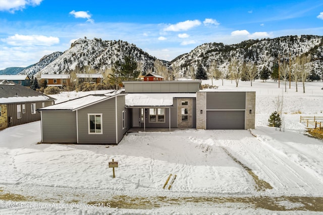 contemporary home with a mountain view and a garage