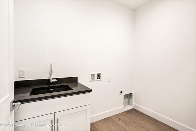 laundry room featuring sink, cabinets, hookup for a washing machine, hookup for an electric dryer, and light hardwood / wood-style floors