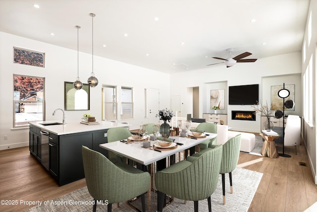 dining space featuring sink, light hardwood / wood-style flooring, and ceiling fan