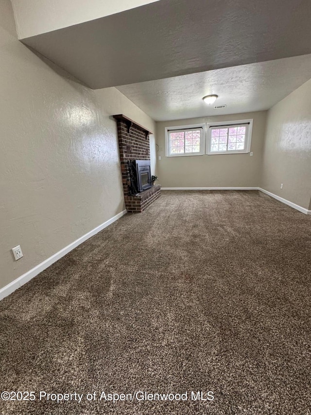 unfurnished living room with baseboards, a brick fireplace, and carpet flooring