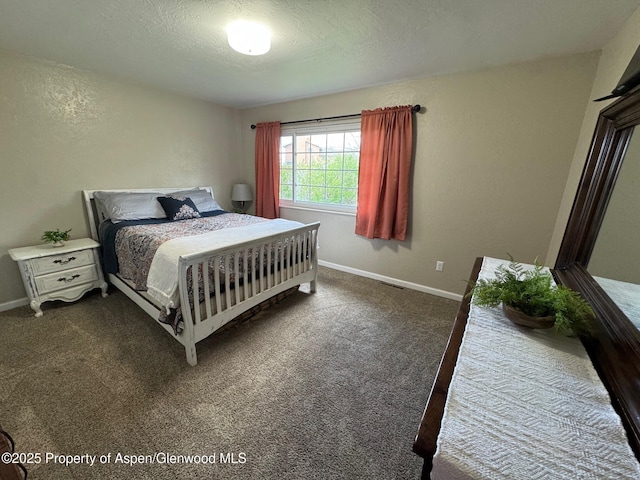 bedroom featuring a textured ceiling, visible vents, baseboards, and dark carpet