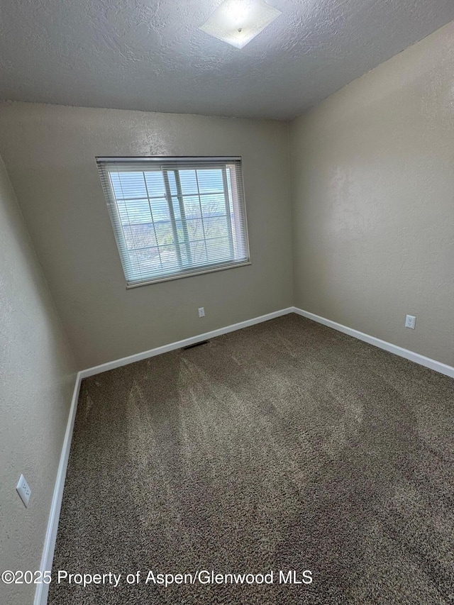 unfurnished room with baseboards, a textured ceiling, and carpet floors