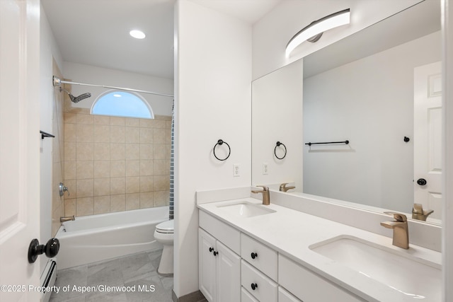 bathroom featuring a sink, toilet,  shower combination, and double vanity