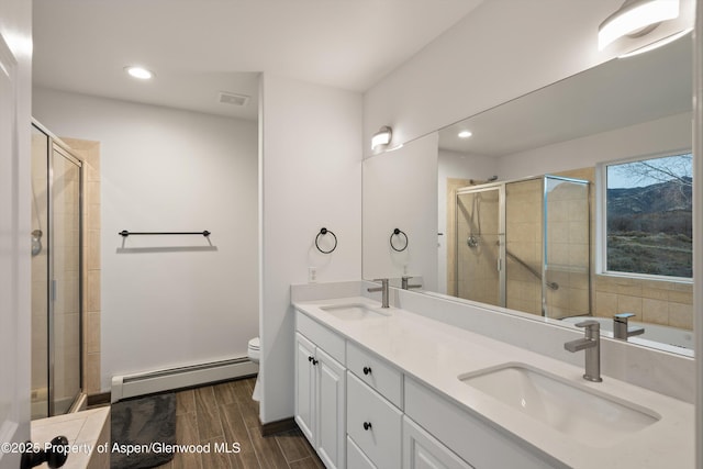 bathroom with a sink, a baseboard radiator, toilet, and a shower stall