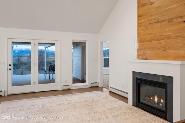 unfurnished living room featuring vaulted ceiling, baseboard heating, a glass covered fireplace, and a baseboard radiator