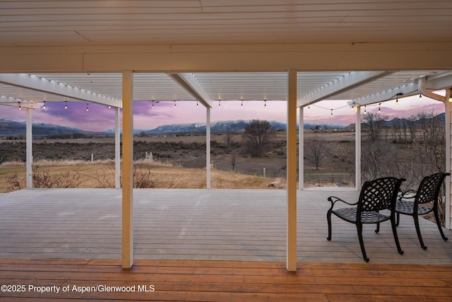 wooden deck featuring a mountain view, a rural view, and a pergola