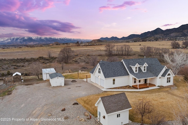 aerial view at dusk with a rural view and a mountain view