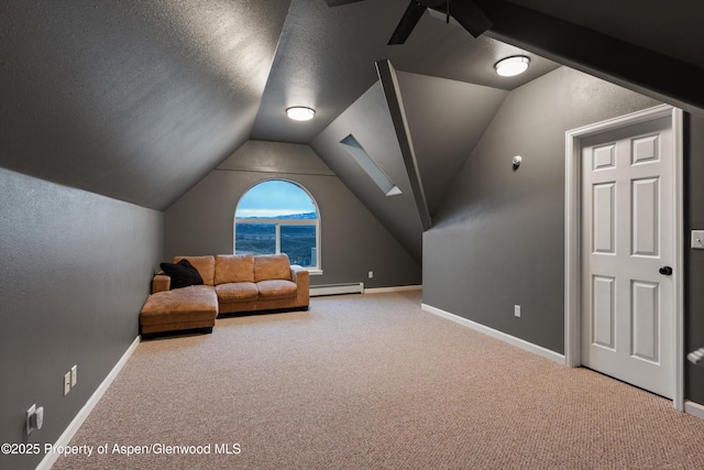 interior space with baseboard heating, carpet flooring, baseboards, and vaulted ceiling