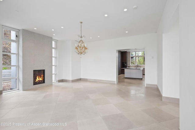 401 Eagle Park Dr, Aspen, CO 81611 - unfurnished living room featuring recessed lighting, a fireplace, a sink, a chandelier, and light tile patterned floors