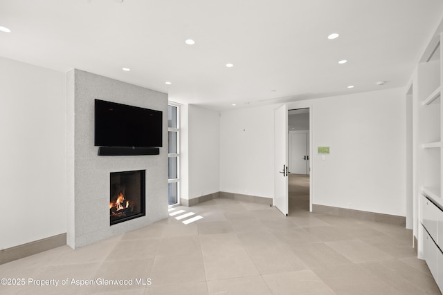 401 Eagle Park Dr, Aspen, CO 81611 - unfurnished living room featuring recessed lighting, a lit fireplace, light tile patterned floors, and baseboards