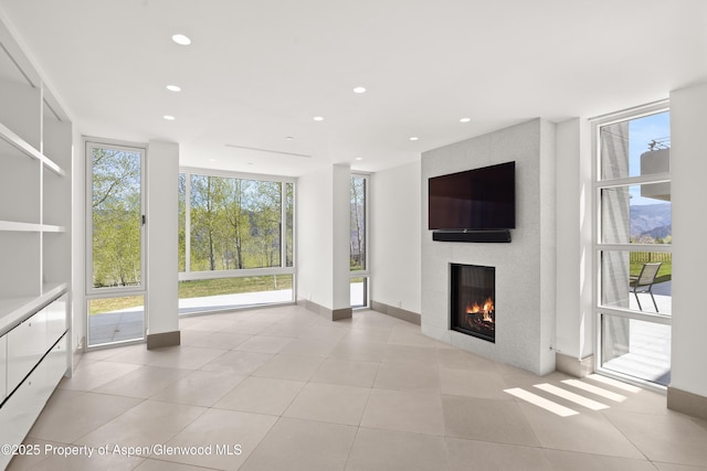 401 Eagle Park Dr, Aspen, CO 81611 - unfurnished living room featuring plenty of natural light, a glass covered fireplace, floor to ceiling windows, recessed lighting, and light tile patterned flooring